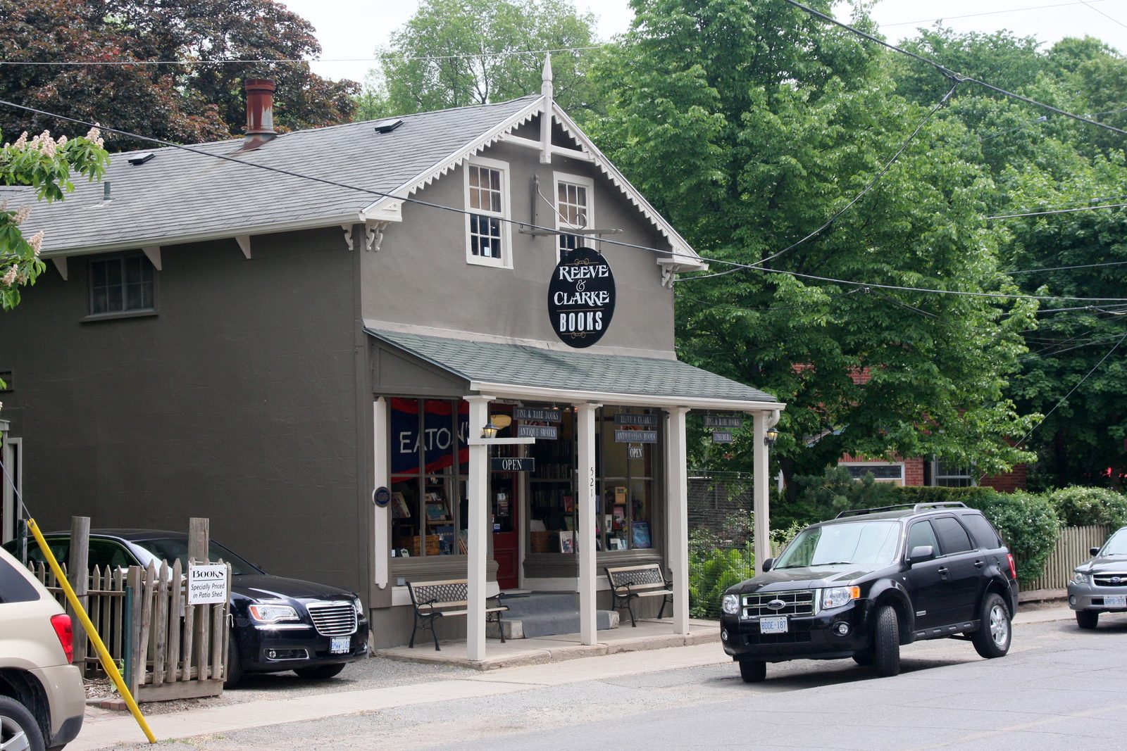Small-town storefront exterior with parked cars and an open sign, representing a Business Owners Policy for small businesses